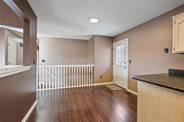 doorway to outside featuring dark hardwood / wood-style flooring and a textured ceiling