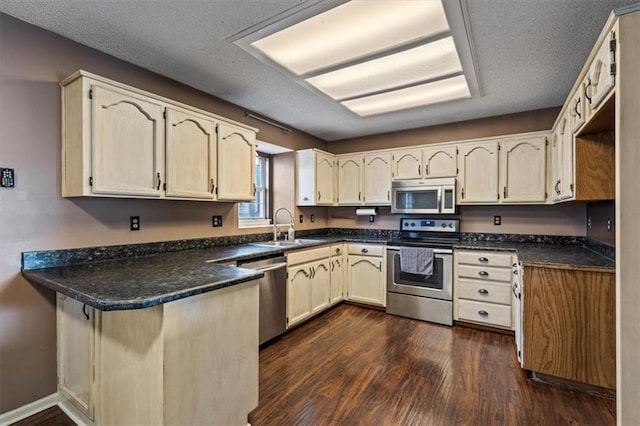 kitchen featuring stainless steel appliances, dark hardwood / wood-style floors, sink, and a textured ceiling