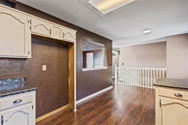 kitchen featuring dark hardwood / wood-style flooring, a textured ceiling, and cream cabinetry