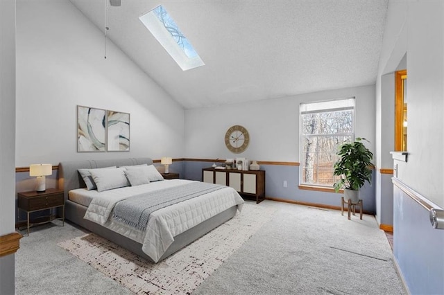 carpeted bedroom with high vaulted ceiling and a skylight