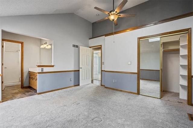 unfurnished bedroom featuring high vaulted ceiling, light colored carpet, a closet, and ceiling fan