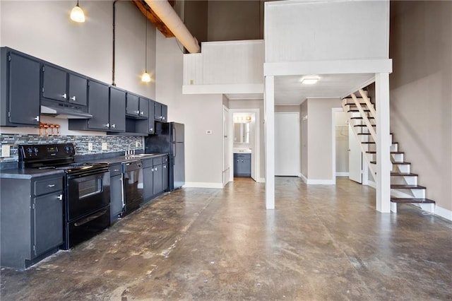 kitchen featuring tasteful backsplash, sink, a high ceiling, hanging light fixtures, and black appliances