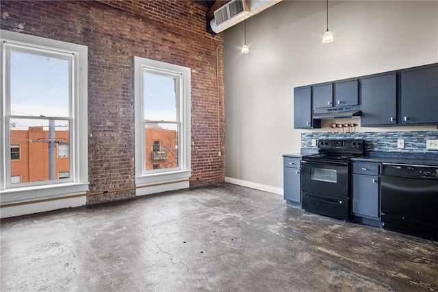 kitchen with a towering ceiling, brick wall, decorative light fixtures, and black appliances