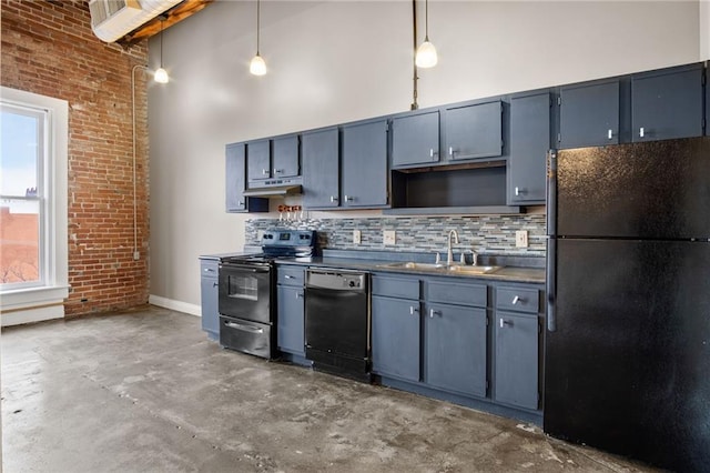 kitchen with pendant lighting, sink, a towering ceiling, and black appliances