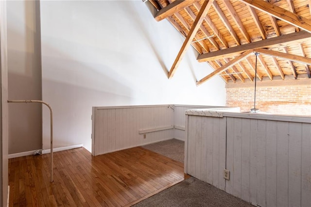 bonus room featuring dark wood-type flooring, lofted ceiling with beams, and wooden ceiling