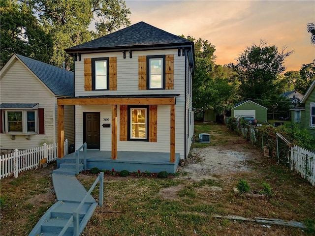 view of front of property featuring central AC unit, a garage, an outdoor structure, and a porch