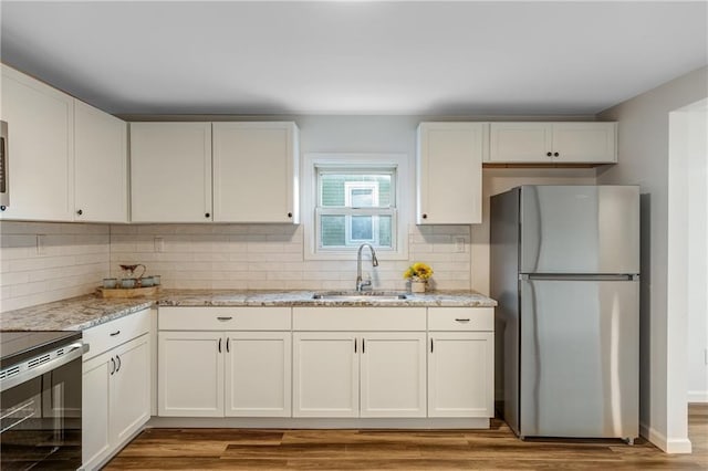 kitchen with stainless steel appliances, white cabinetry, and sink