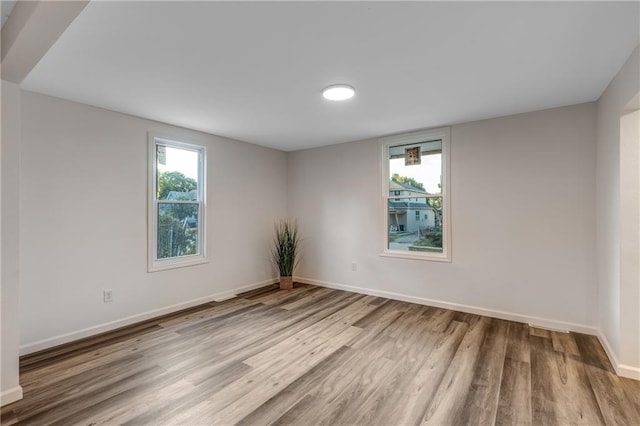 unfurnished room with baseboards and wood finished floors