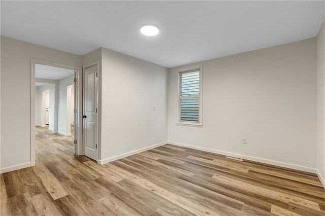 unfurnished room featuring baseboards and light wood-style flooring
