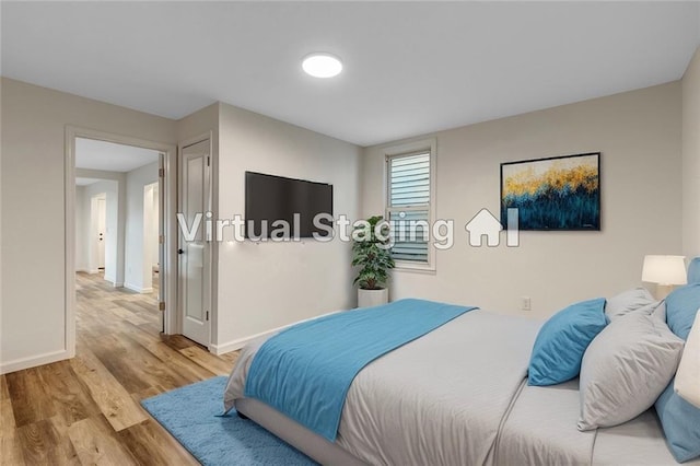 bedroom with baseboards and wood finished floors