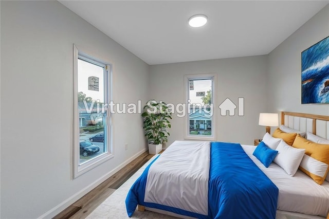 bedroom featuring baseboards and wood finished floors