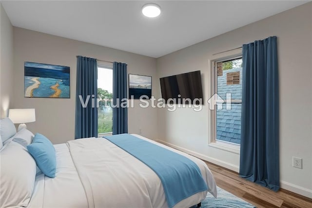 bedroom with baseboards and wood finished floors