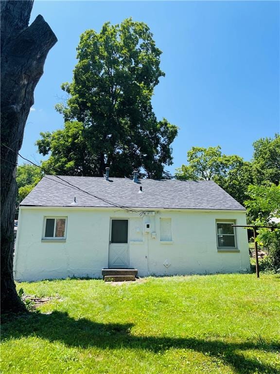 rear view of property with a yard