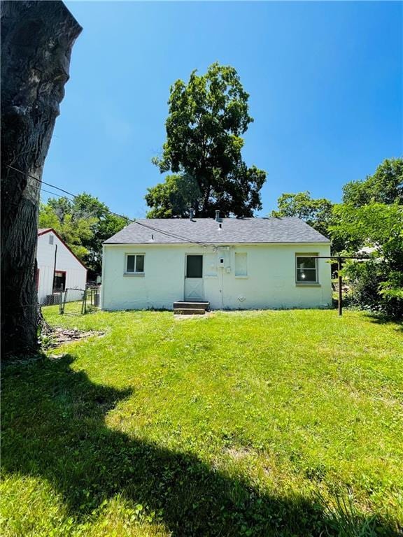 rear view of house featuring a lawn