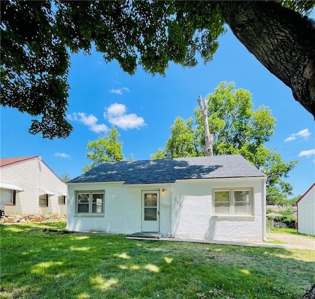 rear view of house featuring a lawn