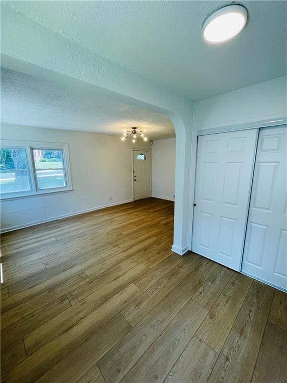 spare room featuring light hardwood / wood-style floors and a textured ceiling