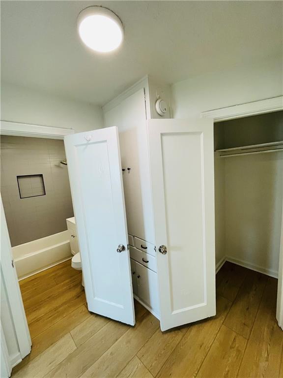 bathroom with hardwood / wood-style flooring and toilet