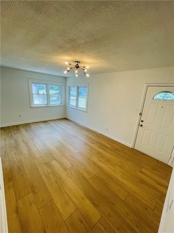 interior space with a textured ceiling and light wood-type flooring