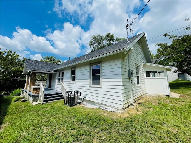 back of house with a wooden deck and a lawn