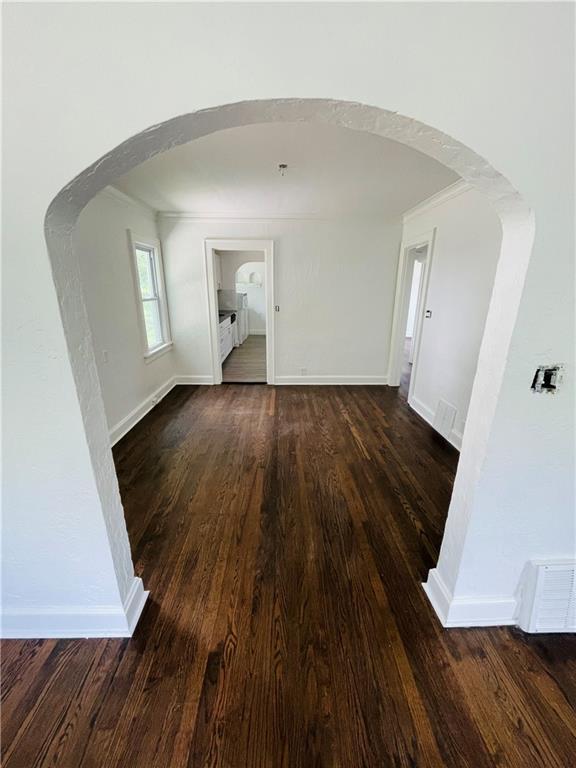 corridor with ornamental molding and dark hardwood / wood-style flooring