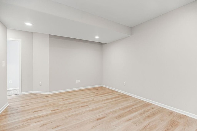 spare room featuring light wood-type flooring, baseboards, and recessed lighting