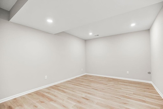 spare room featuring light wood-type flooring, visible vents, baseboards, and recessed lighting