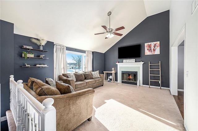 carpeted living room with ceiling fan and lofted ceiling