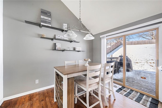 dining space with lofted ceiling and wood-type flooring