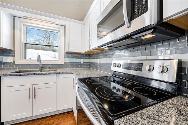 kitchen with sink, hardwood / wood-style floors, stainless steel appliances, light stone countertops, and white cabinets