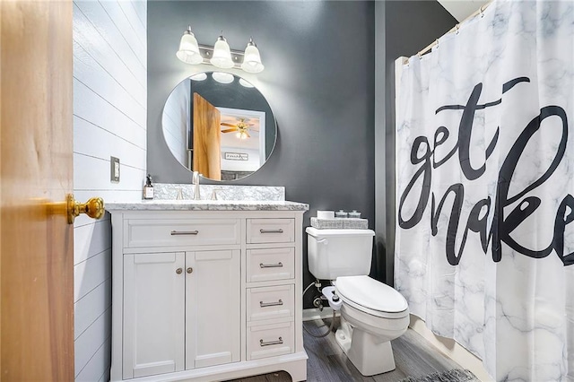 bathroom featuring vanity, hardwood / wood-style floors, curtained shower, and toilet