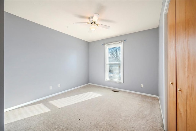 carpeted empty room featuring ceiling fan