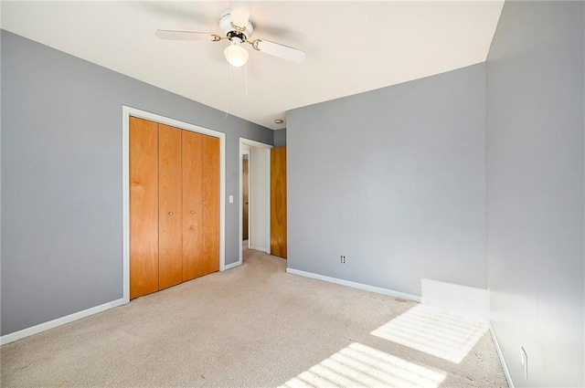 unfurnished bedroom with light carpet, ceiling fan, and a closet