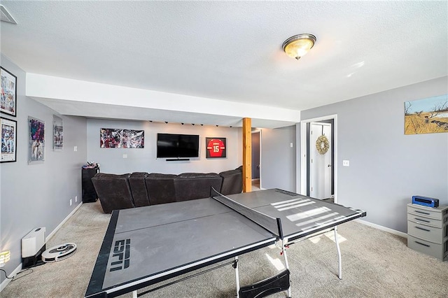 recreation room featuring light colored carpet and a textured ceiling