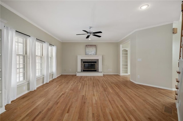 unfurnished living room with crown molding, ceiling fan, built in shelves, and light hardwood / wood-style flooring