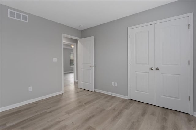 unfurnished bedroom featuring light hardwood / wood-style floors and a closet