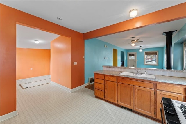 kitchen featuring ceiling fan, white gas range, and sink