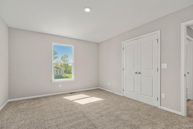 unfurnished bedroom featuring carpet floors, baseboards, and a closet