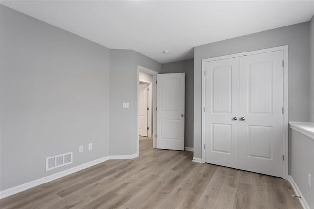 unfurnished bedroom with light hardwood / wood-style floors and a closet