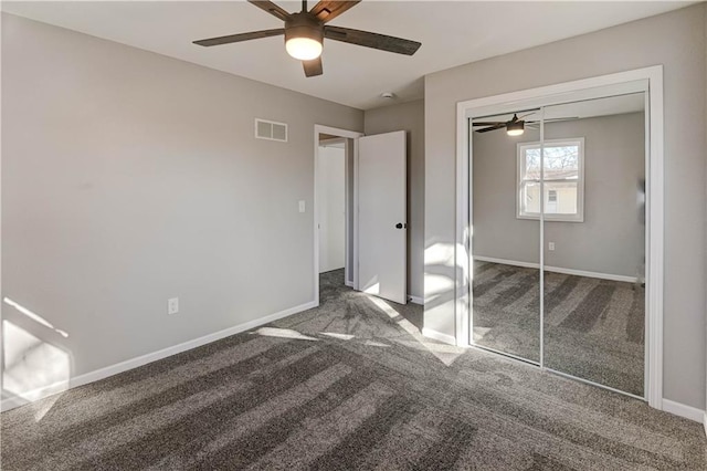 unfurnished bedroom with dark colored carpet, ceiling fan, and a closet