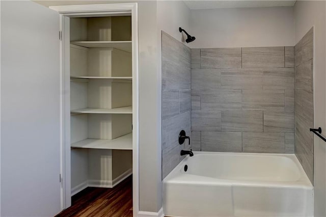 bathroom featuring wood-type flooring and tiled shower / bath