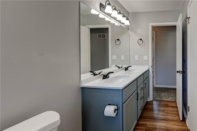 bathroom featuring vanity, wood-type flooring, and toilet