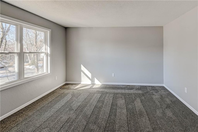 unfurnished room featuring dark colored carpet