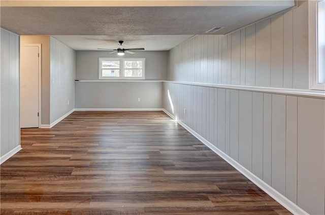 basement featuring ceiling fan and dark hardwood / wood-style flooring