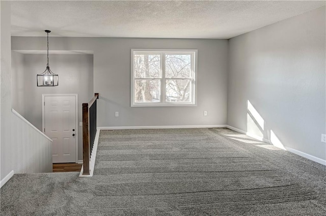 interior space with a chandelier, carpet, and a textured ceiling