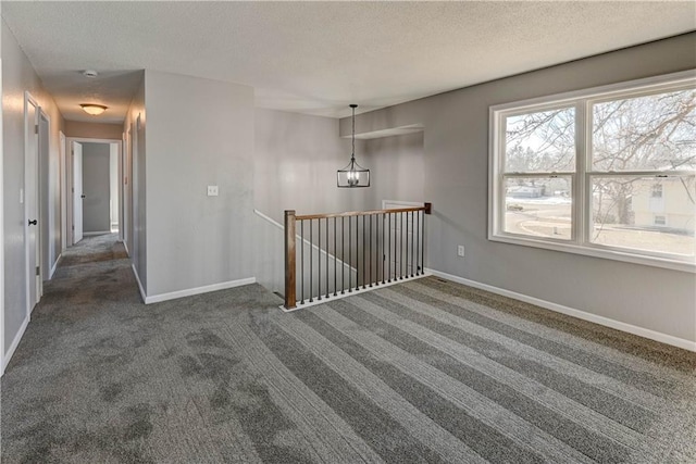 carpeted spare room with a textured ceiling