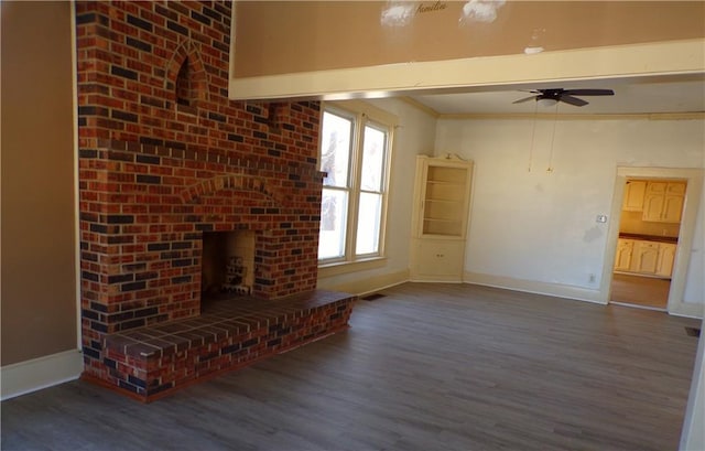 unfurnished living room with hardwood / wood-style flooring, ceiling fan, beam ceiling, and a brick fireplace