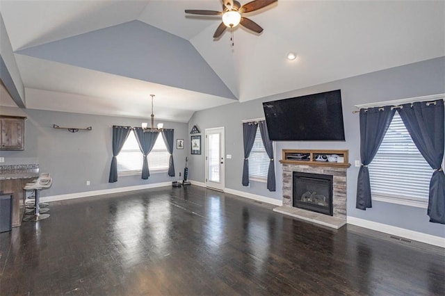 living room with hardwood / wood-style flooring, lofted ceiling, a fireplace, and ceiling fan with notable chandelier