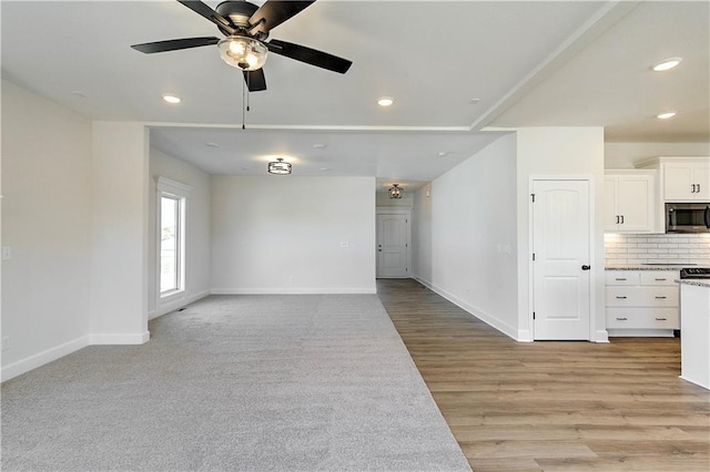 unfurnished living room featuring light hardwood / wood-style flooring and ceiling fan