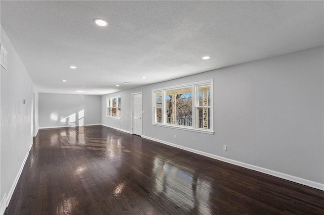 unfurnished living room with wood-type flooring and a textured ceiling