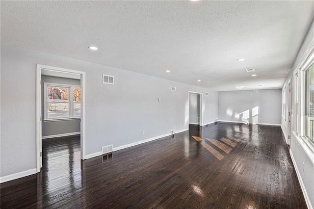 spare room with dark wood-type flooring and a textured ceiling